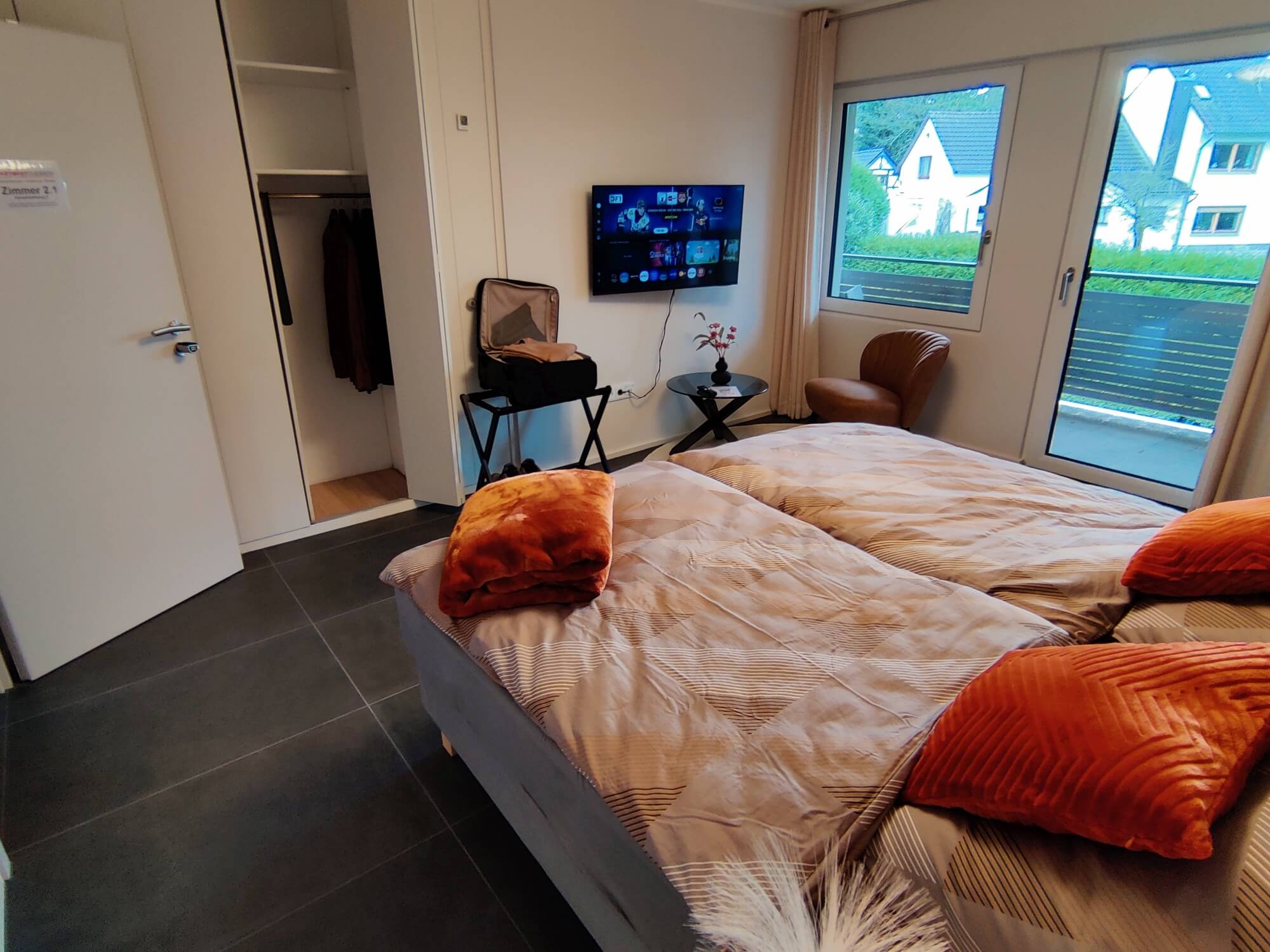 Modern eingerichtetes Schlafzimmer in der Ferienwohnung Overath mit komfortablen Einzelbetten und Nachttischlampen.